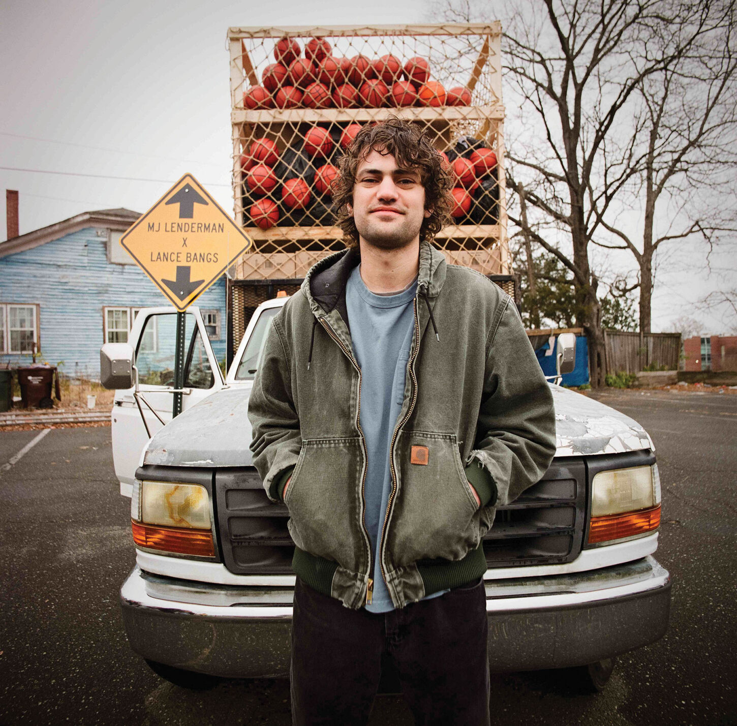 MJ Lenderman press photo artist stands in front of a truck loaded with basketballs